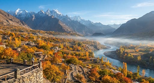 Hunza valley in autumn, with golden apricot orchards, a river, and snow-dusted peaks